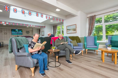 Residents reading books in a common area.