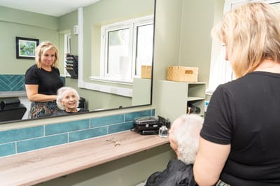 Stylist working with a senior resident in a salon