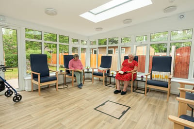 Two residents in a sunlit common area