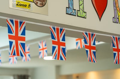 Bunting flags with Union Jack design hanging indoors.
