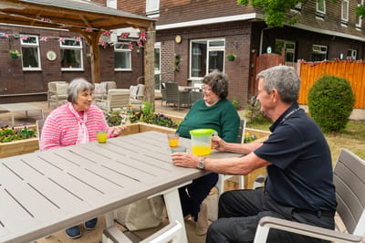 Residents enjoying drinks in a garden area