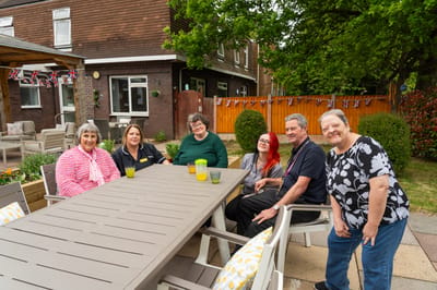 Residents and staff socializing outdoors.
