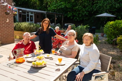 Residents enjoying drinks and snacks outdoors.
