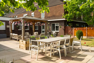 Outdoor seating area with a gazebo and greenery.