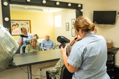 Residents in a hair salon receiving services