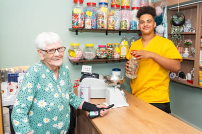 Resident and staff interacting at a facility shop