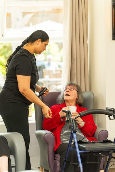 Staff member assisting resident in common area.