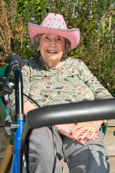 Elderly woman with a pink hat outdoors