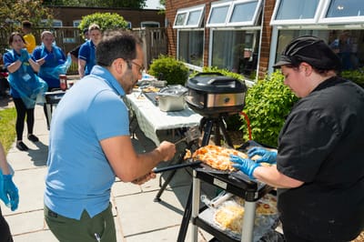 Staff and residents prepare food outdoors