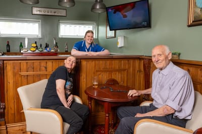 Residents enjoying time with staff in a lounge area.