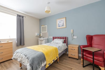 Cozy bedroom with a bed and armchair.