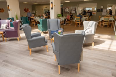 Common area with chairs and residents socializing.