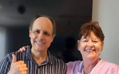 Smiling staff member with a resident in casual setting.