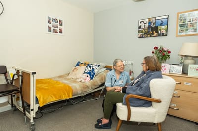 Staff assisting a resident in a cozy room.