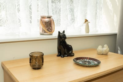Decorative items on a wooden surface by a window
