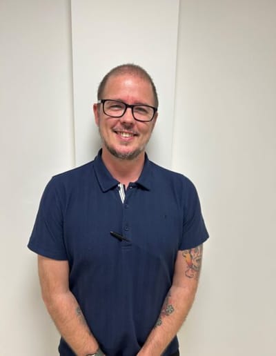 Staff member smiling in a facility setting.