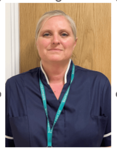 Care staff member in uniform in hallway.