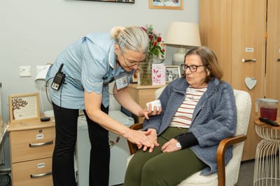 Staff assisting a resident in a cozy room