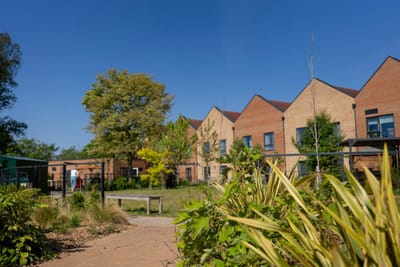 Outdoor area with greenery and building facade.