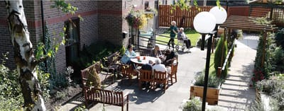 Residents enjoying an outdoor space with seating and tables.