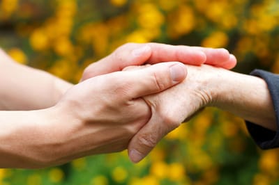 Two hands holding, symbolizing care and connection.