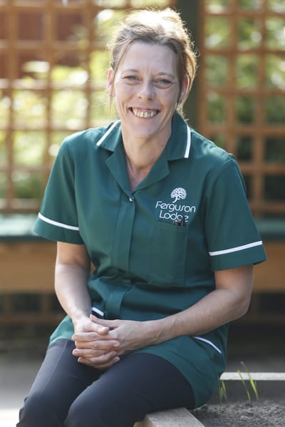 Staff member smiling in outdoor space.
