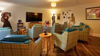 Common area with chairs and seated residents.