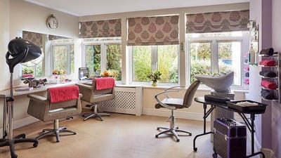 Beauty salon area with salon chairs and plants.