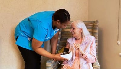 Staff member assisting resident with health monitor
