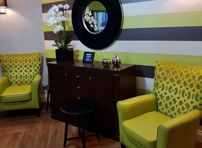 Interior seating area with green chairs and decorative accents.
