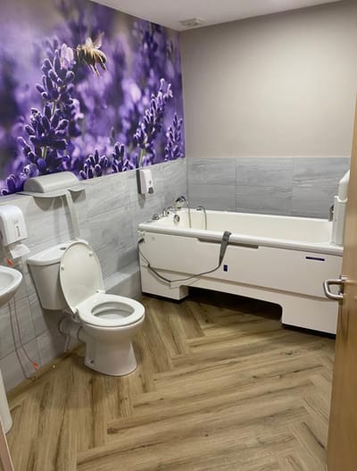 Accessible bathroom with modern amenities and floral wallpaper