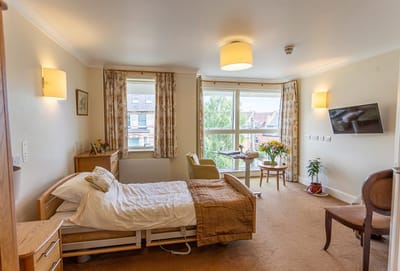Cozy resident room with bed and seating area.
