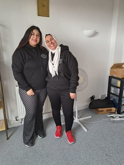 Two staff members posing in a casual setting.