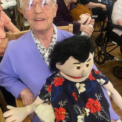 Senior resident with puppet during activity