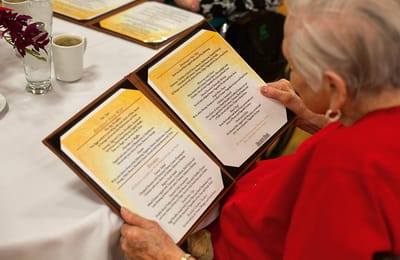 Resident reading a menu in a dining area
