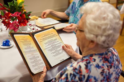 Senior resident reading a menu in a dining area