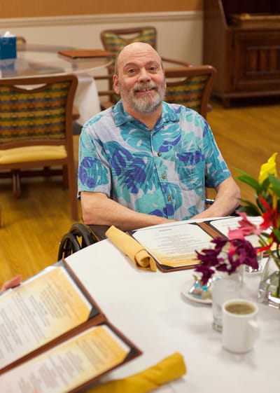 Resident enjoying a meal in the dining room.
