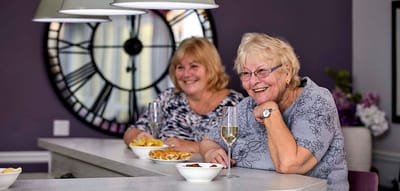 Two women enjoying snacks and drinks at a bar