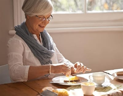 Senior woman enjoying breakfast at a table
