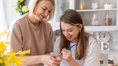 Two people painting together in a cozy setting.