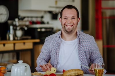 Man with Down syndrome enjoying a meal.