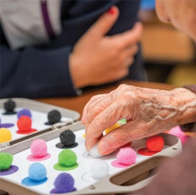 Senior hands engaged in a colorful activity.