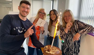 Staff celebrating a birthday with a cake.