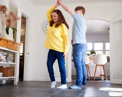 Two people dancing in a bright interior space.