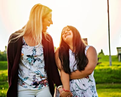 Two women enjoying time together outdoors, smiling.