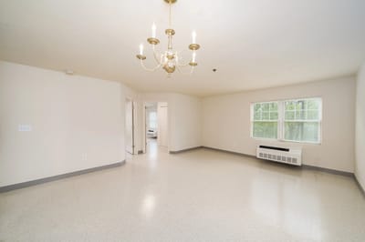 Empty common area with a chandelier and window.