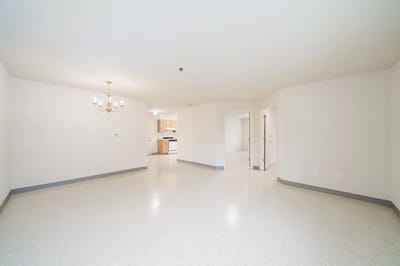 Empty common area with light-colored walls and a chandelier.