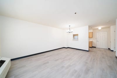 Empty interior room with light wood flooring.