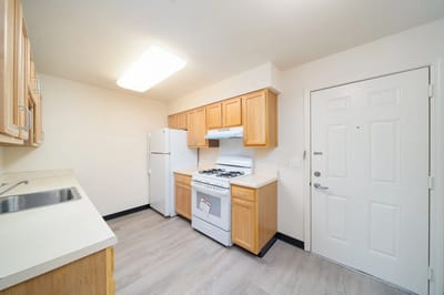 Clean kitchen with basic appliances and cabinets.