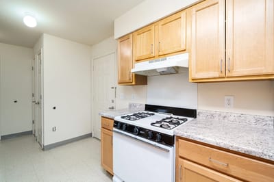 Clean kitchen space with cabinets and stove.